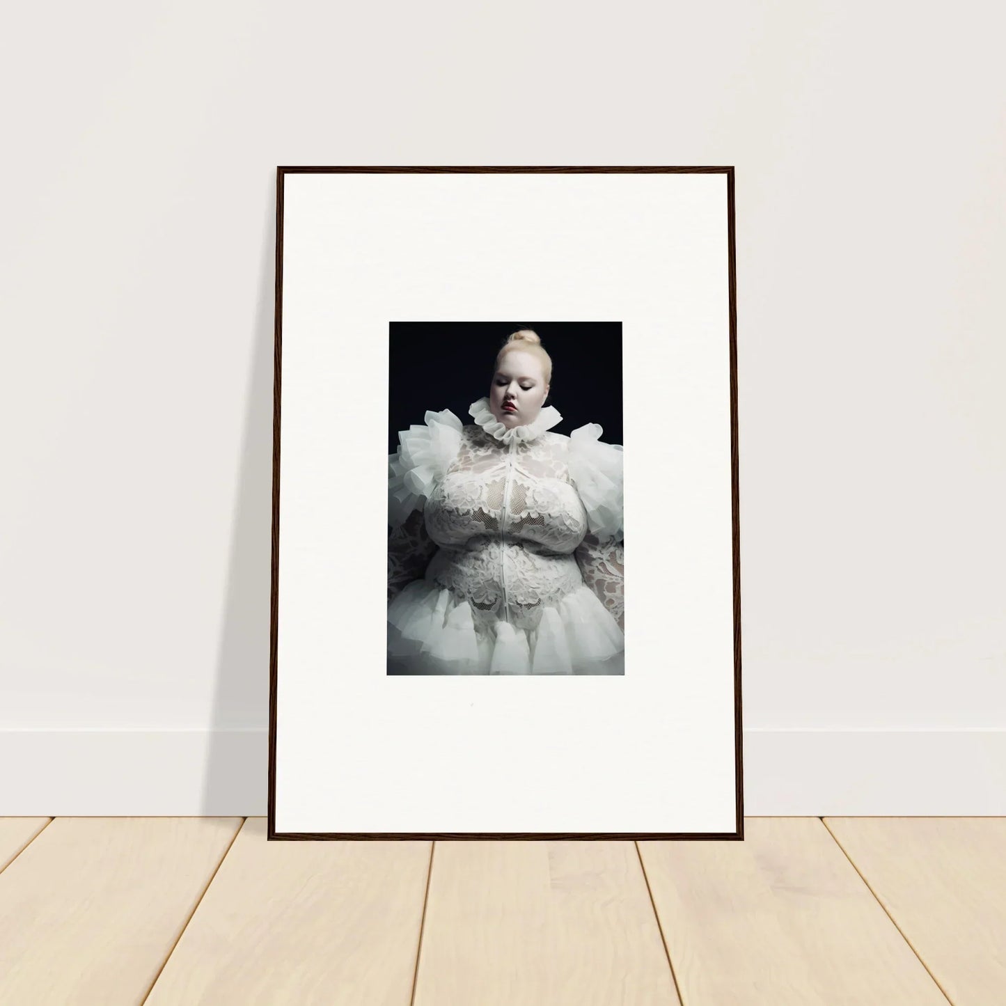 Framed black and white photograph of a person wearing an elaborate white ruffled costume.