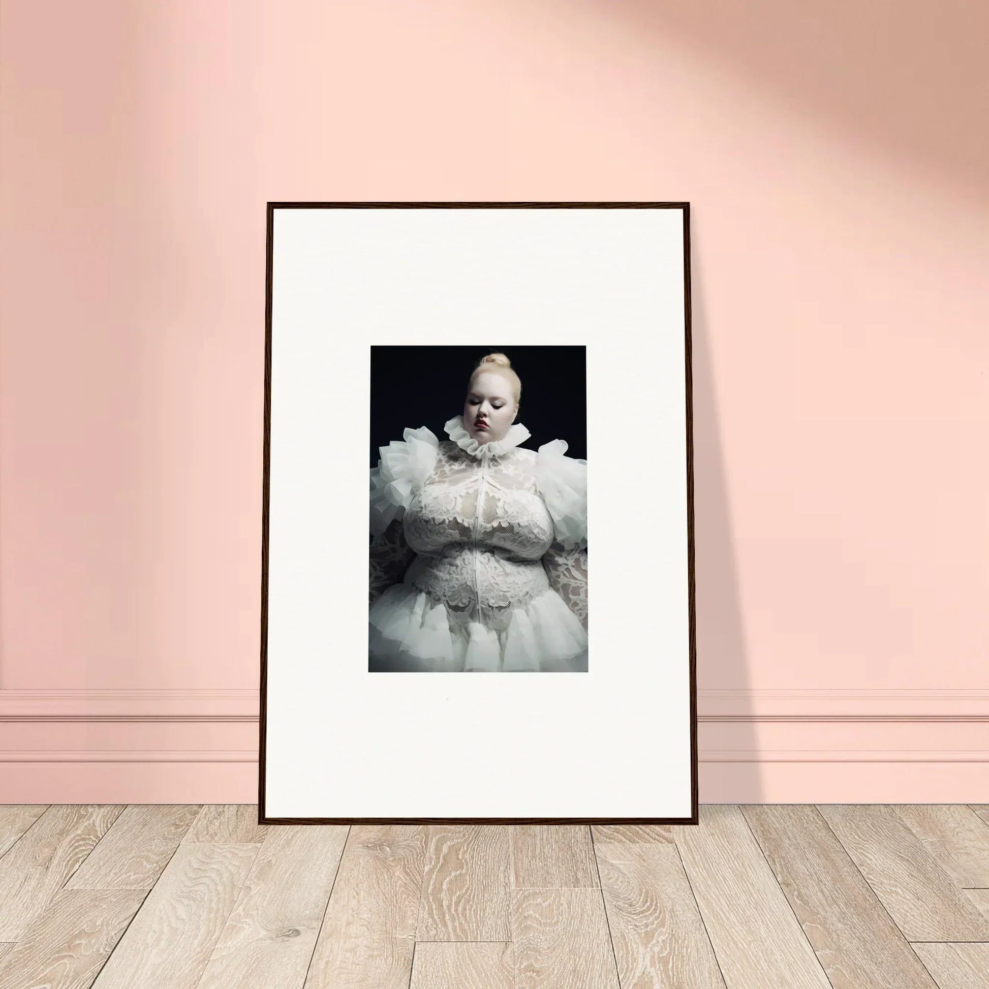 Framed black and white photograph of a baby wearing an ornate white outfit.
