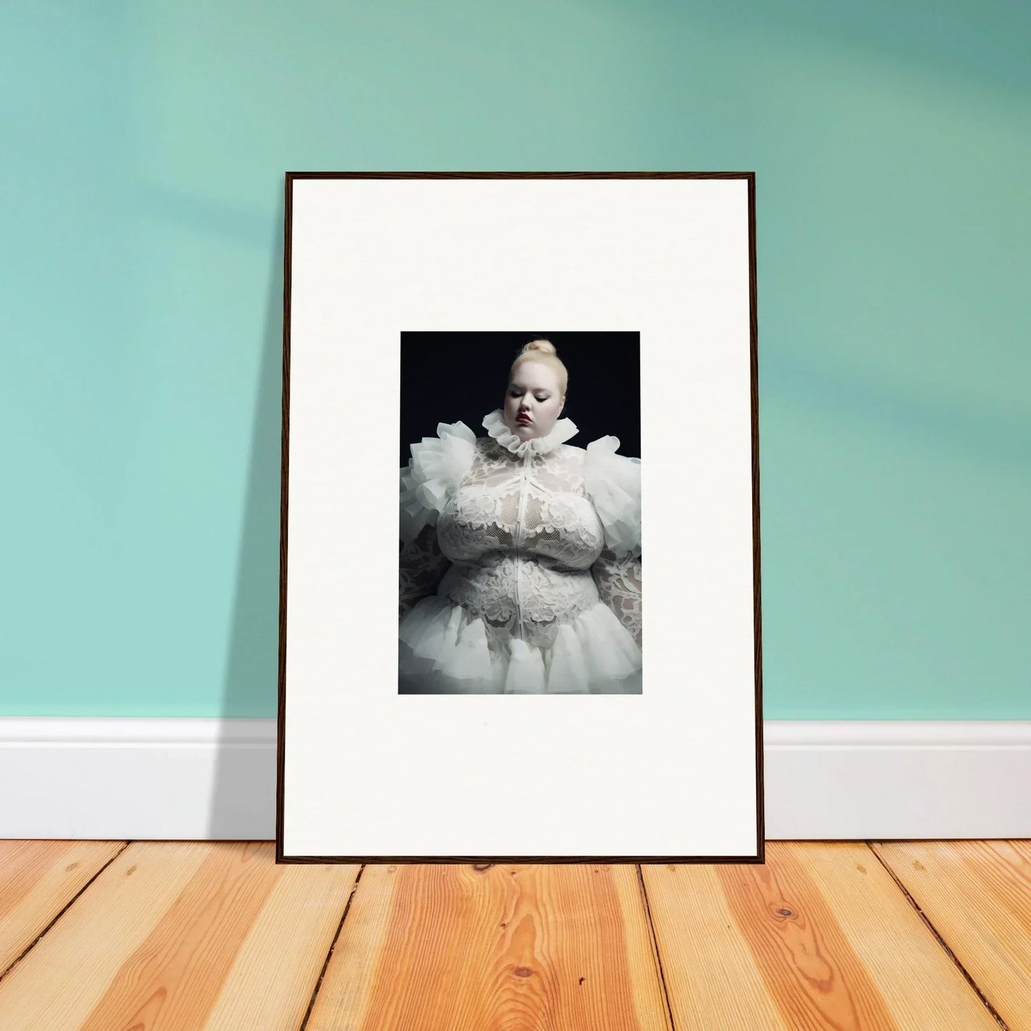 Framed black and white photograph of an infant wearing an elaborate white outfit.