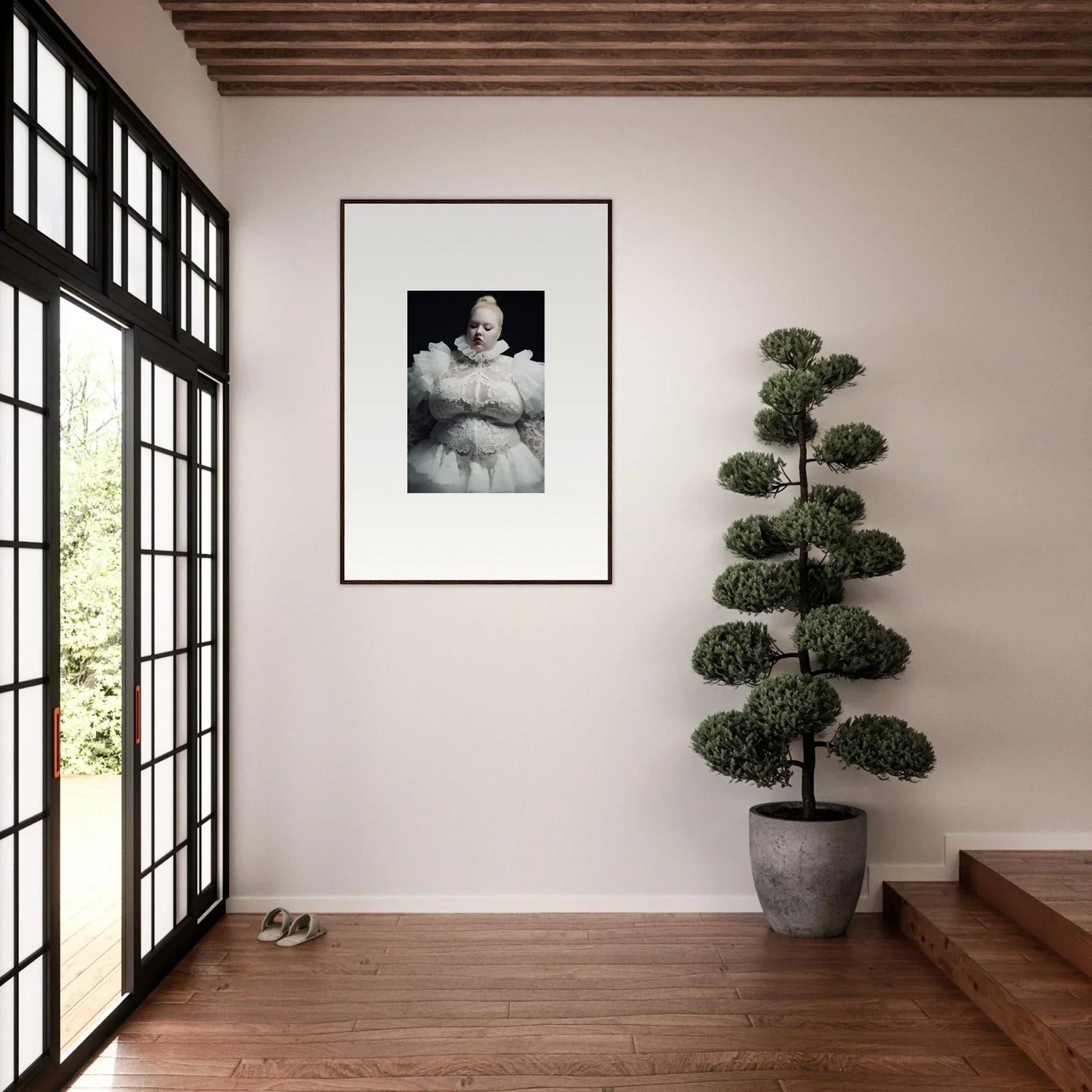 Framed black and white portrait photograph hanging on a white wall.