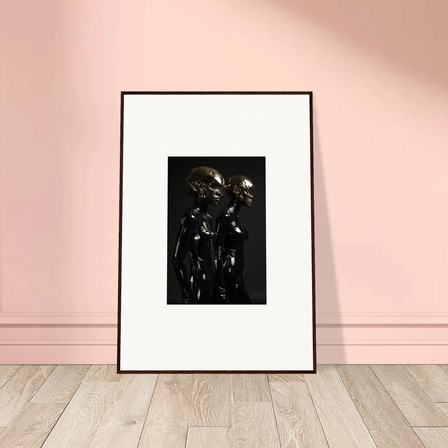 Framed black and white photograph depicting two figures in dark, reflective attire.