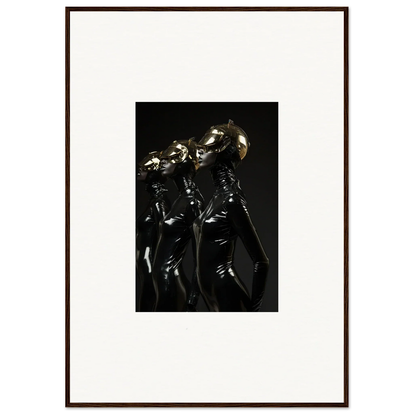 Framed photograph of three figures in shiny, dark outfits with metallic headpieces.