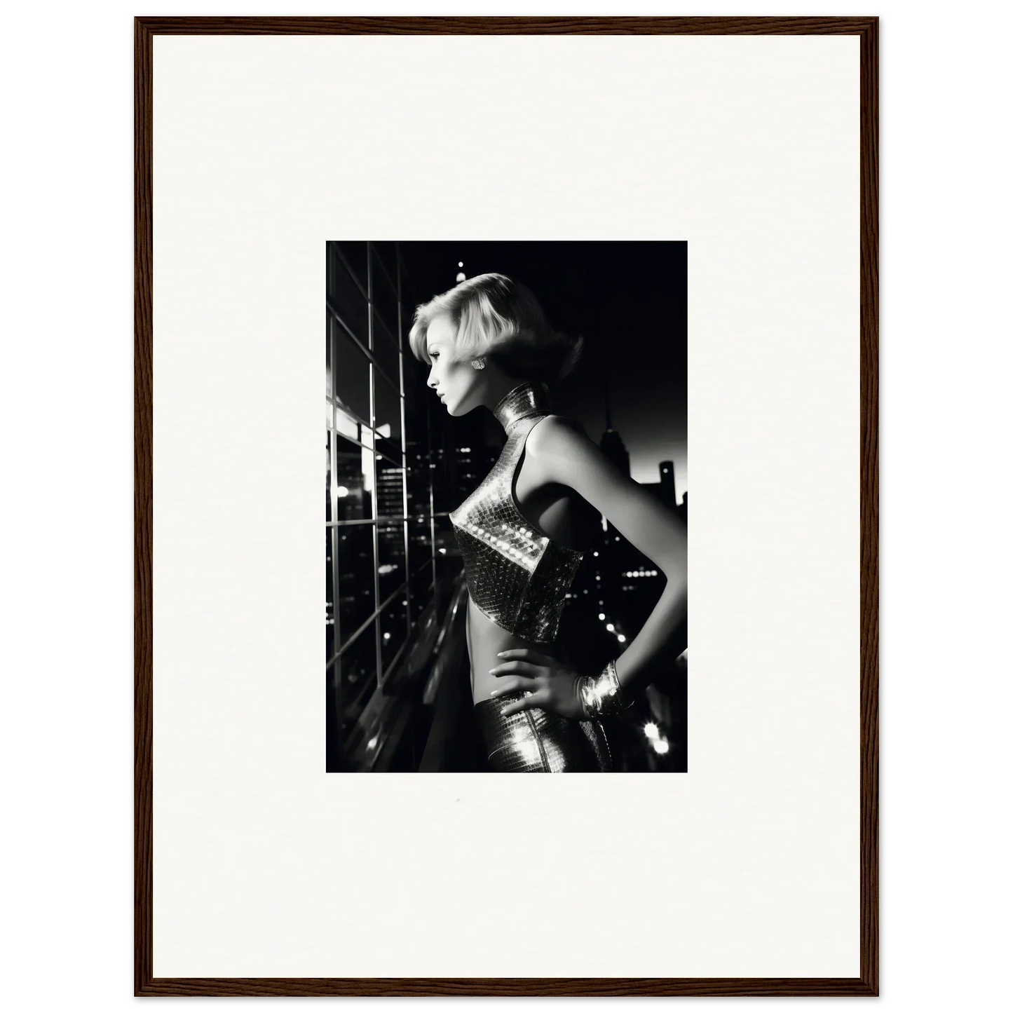 Black and white photograph of a woman in a shimmering dress with short blonde hair.
