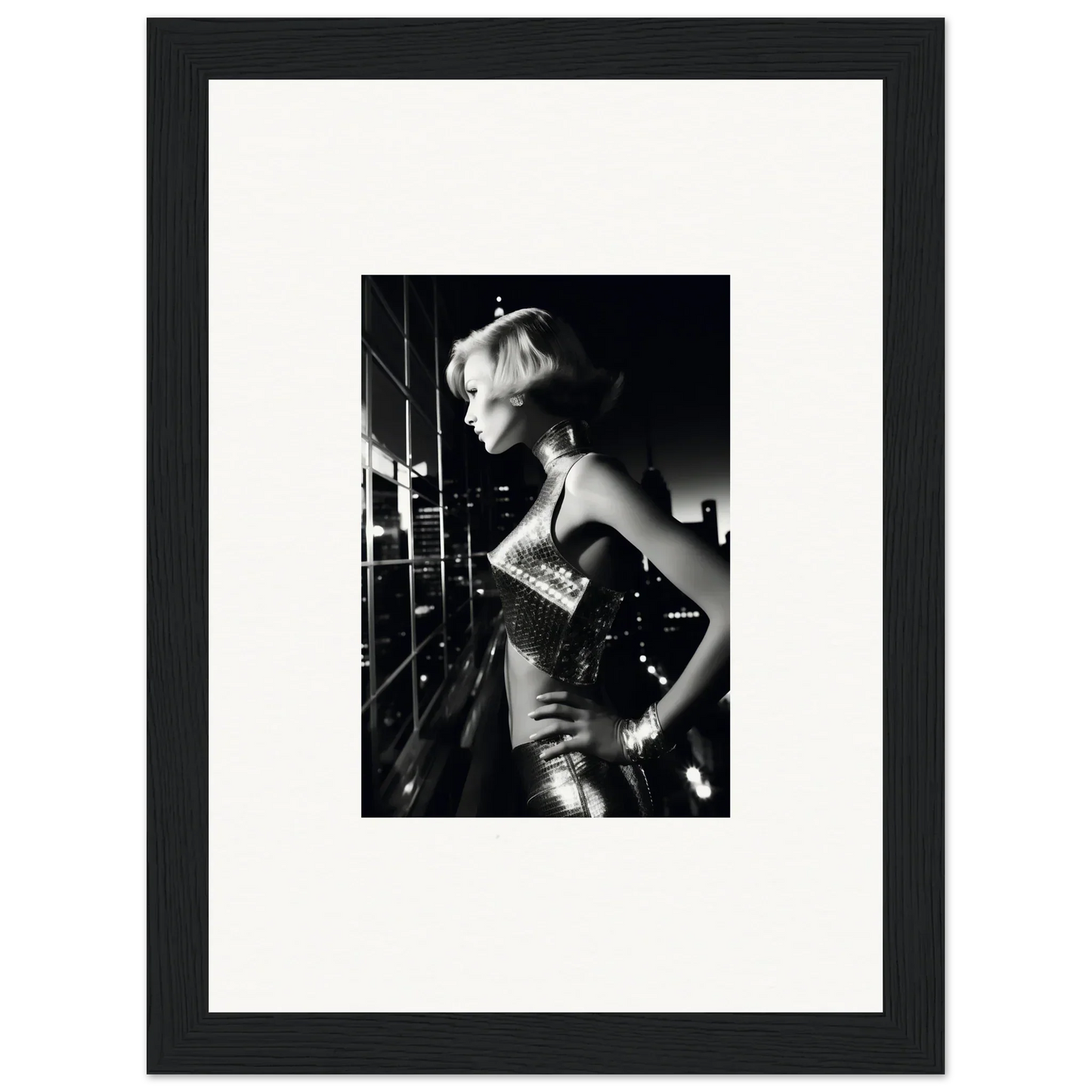 Black and white photograph of a woman in a sparkly dress with short blonde hair, framed in a simple black frame.