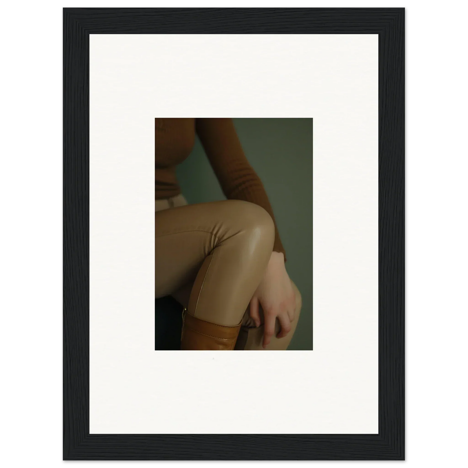 Framed photograph showing a close-up of a person’s hip and thigh in beige pants.