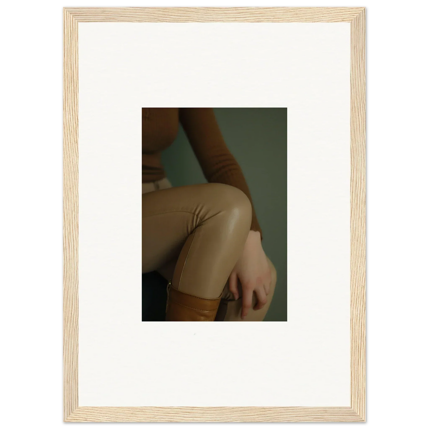 Framed photograph showing a close-up view of a person’s torso wearing beige clothing.