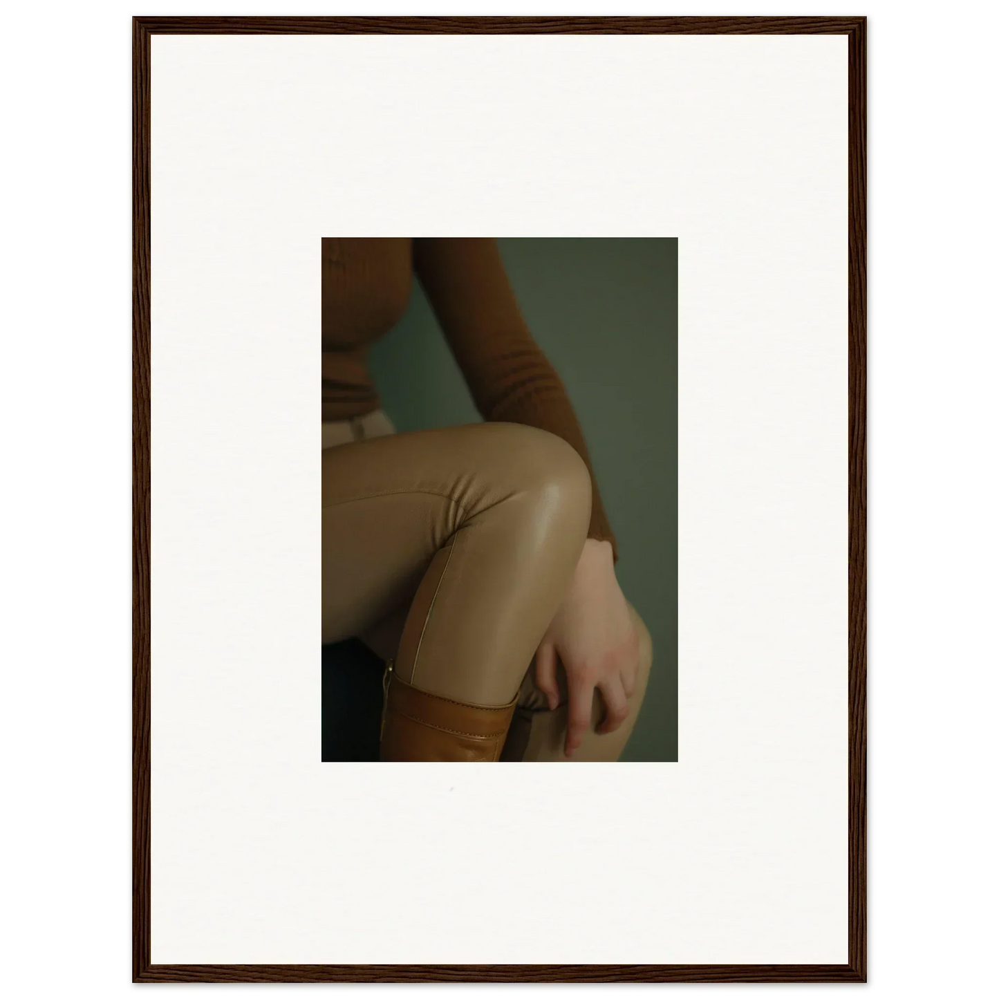 Framed photograph showing a close-up of a person’s arm and torso wearing beige clothing.