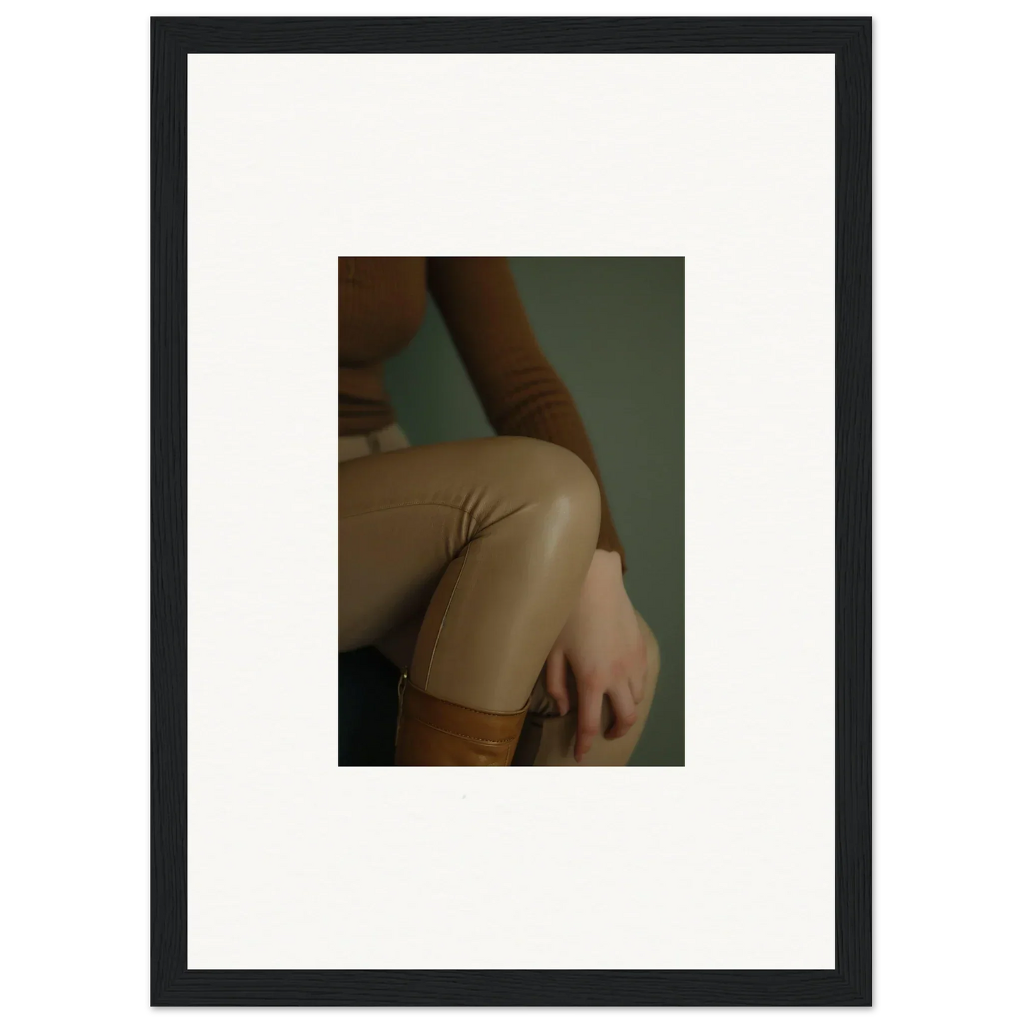 Framed photograph showing a close-up of a person’s torso wearing a beige or tan garment.