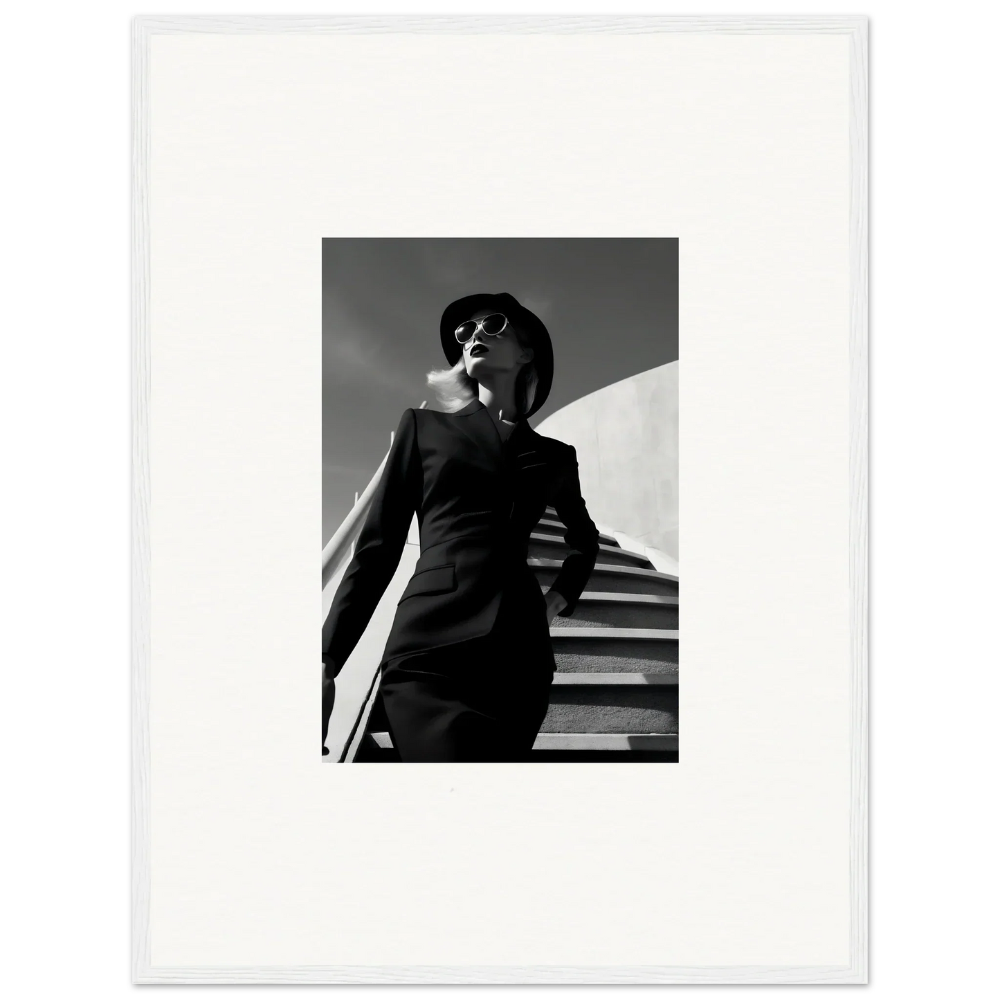 Black and white photograph of a stylishly dressed woman on stairs.