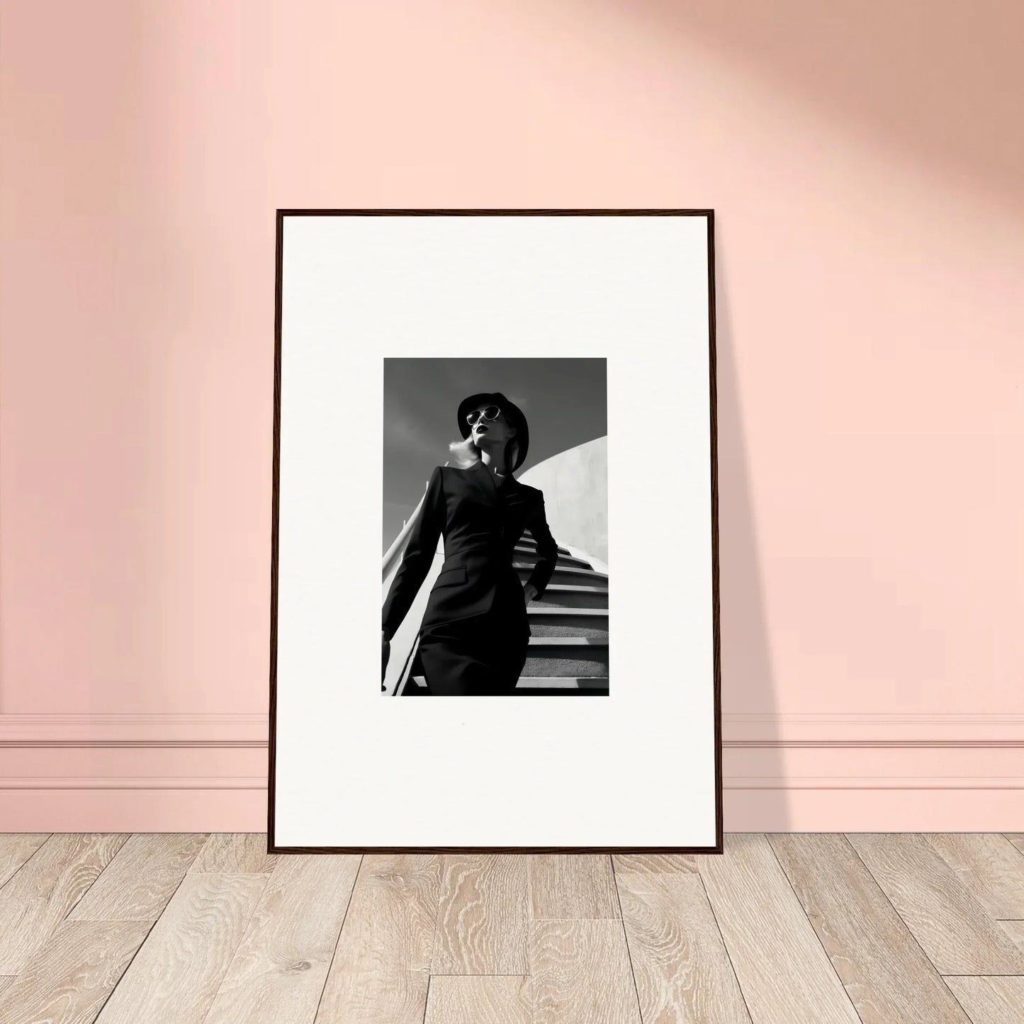 Framed black and white photograph of a person on stairs with dramatic lighting.