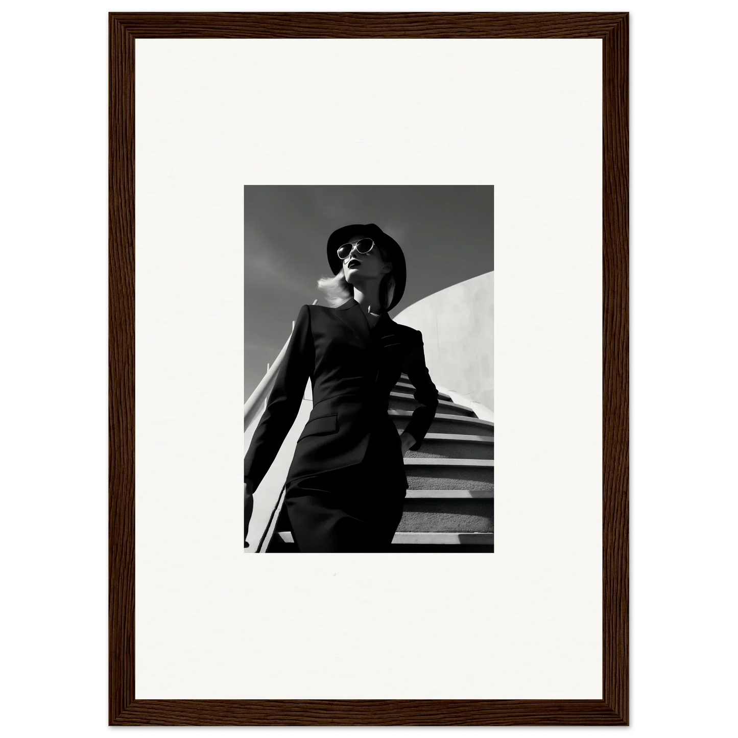 Black and white photograph of a stylishly dressed person wearing sunglasses and a hat.
