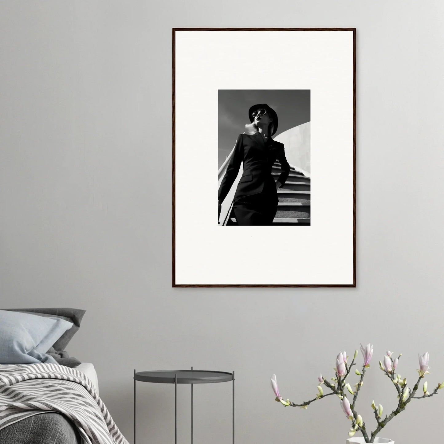 Framed black and white photograph of a person in a stylish outfit standing on stairs.