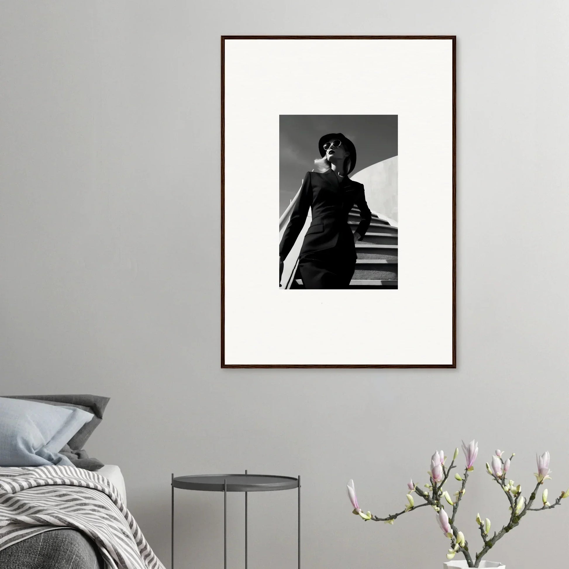 Framed black and white photograph of a person in a stylish outfit standing on stairs.