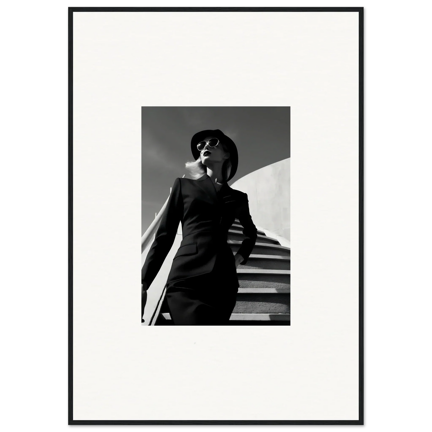 Black and white photograph of a person in a suit and sunglasses standing on stairs.