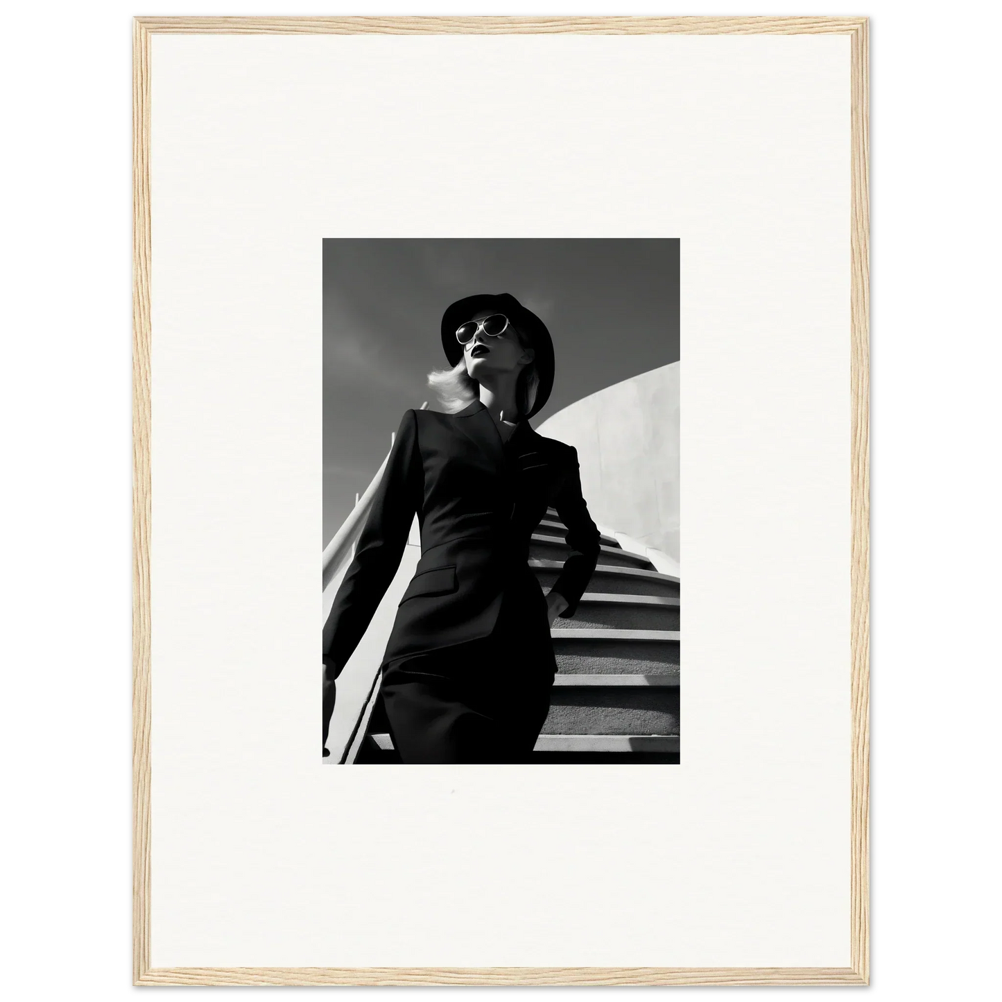 Black and white photograph of a stylishly dressed woman on stairs.