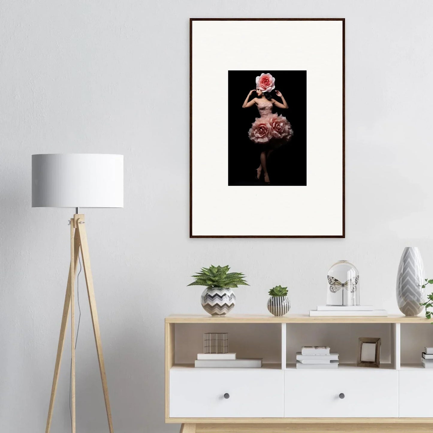 Framed artwork depicting a figure in an elaborate floral dress against a dark background.