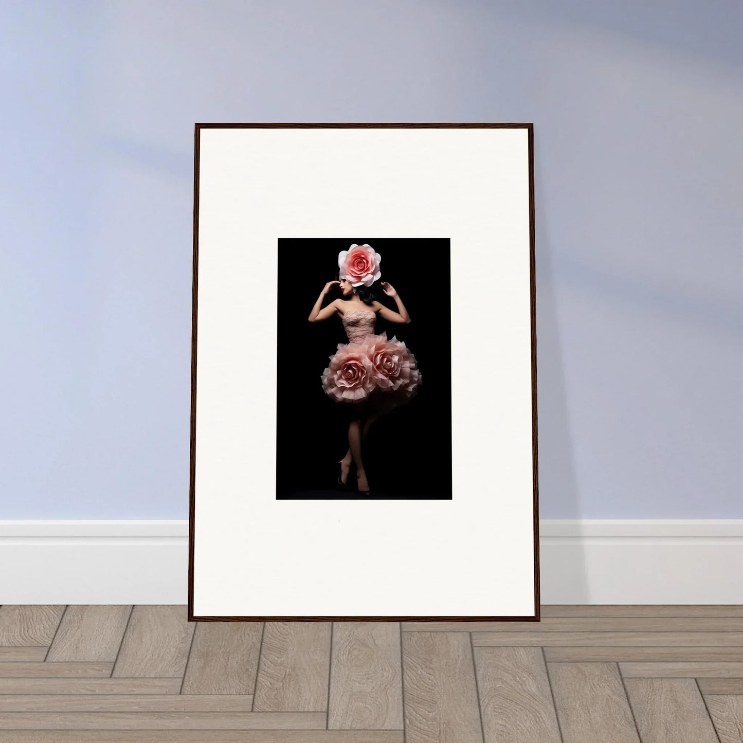 Framed artwork depicting a figure with a floral headdress and skirt against a dark background.