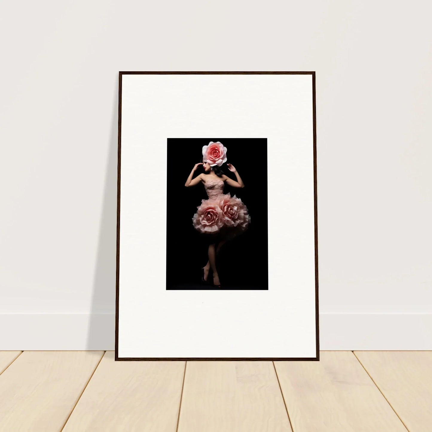Framed artwork depicting a figure adorned with floral elements against a dark background.