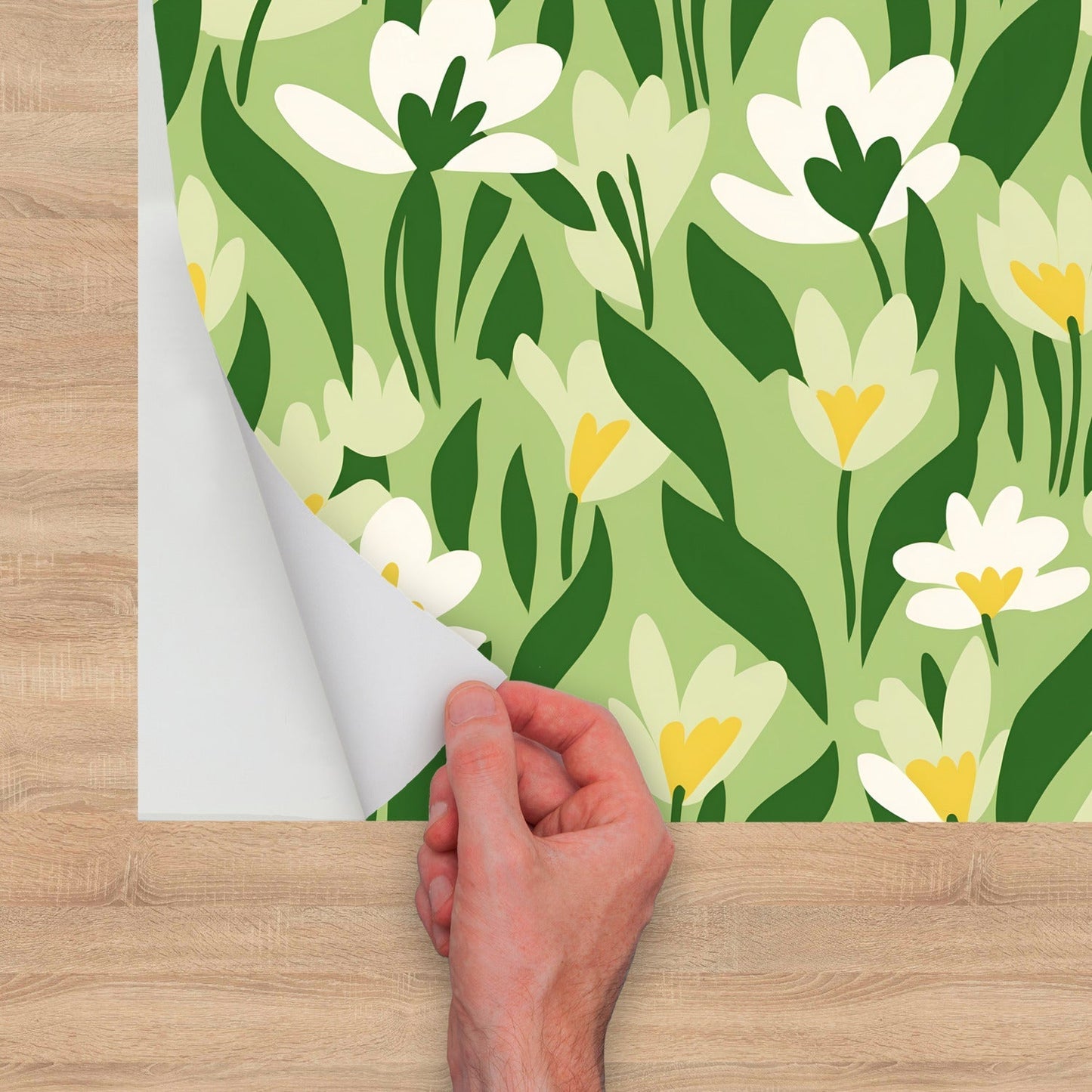 A hand holding a piece of paper with a pattern of white flowers