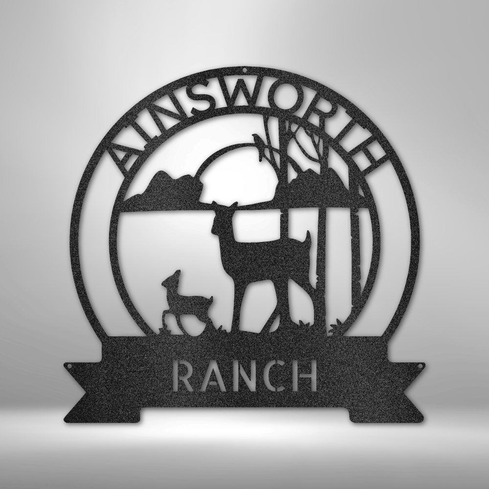 Circular metal sign for Ainsworth Ranch featuring silhouettes of deer and trees.