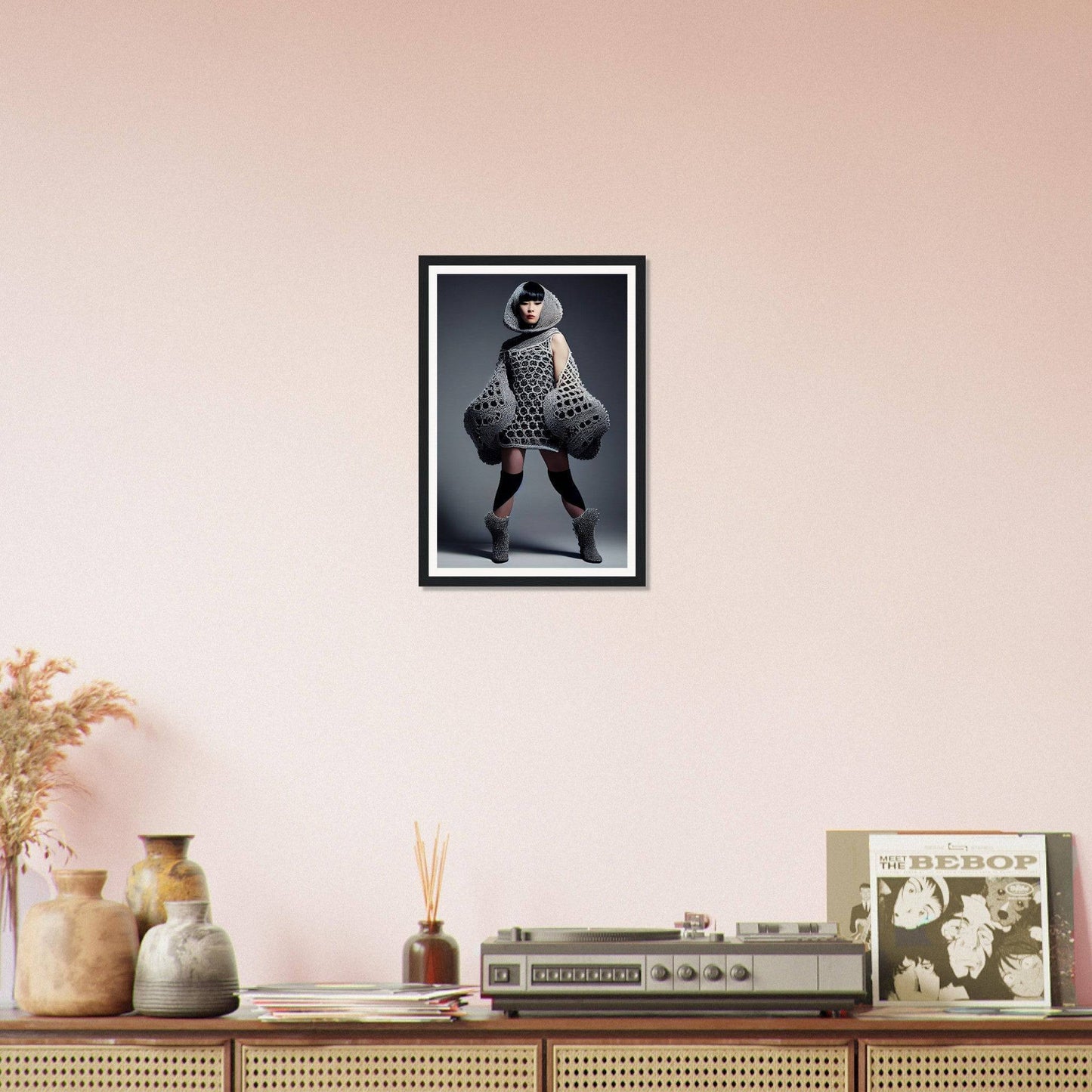 Framed black and white photograph of a person in an avant-garde outfit with exaggerated spherical shapes.
