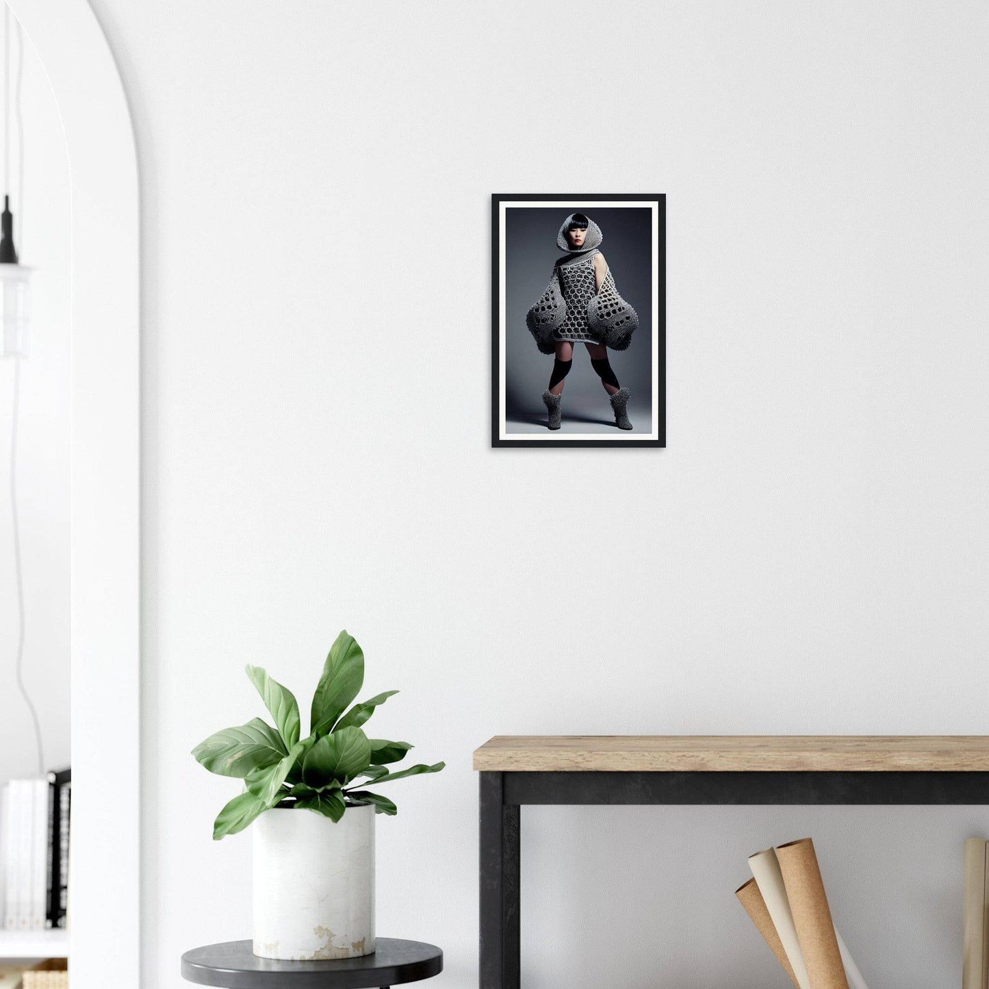 Framed black and white photograph of a person in an avant-garde outfit posing dramatically.