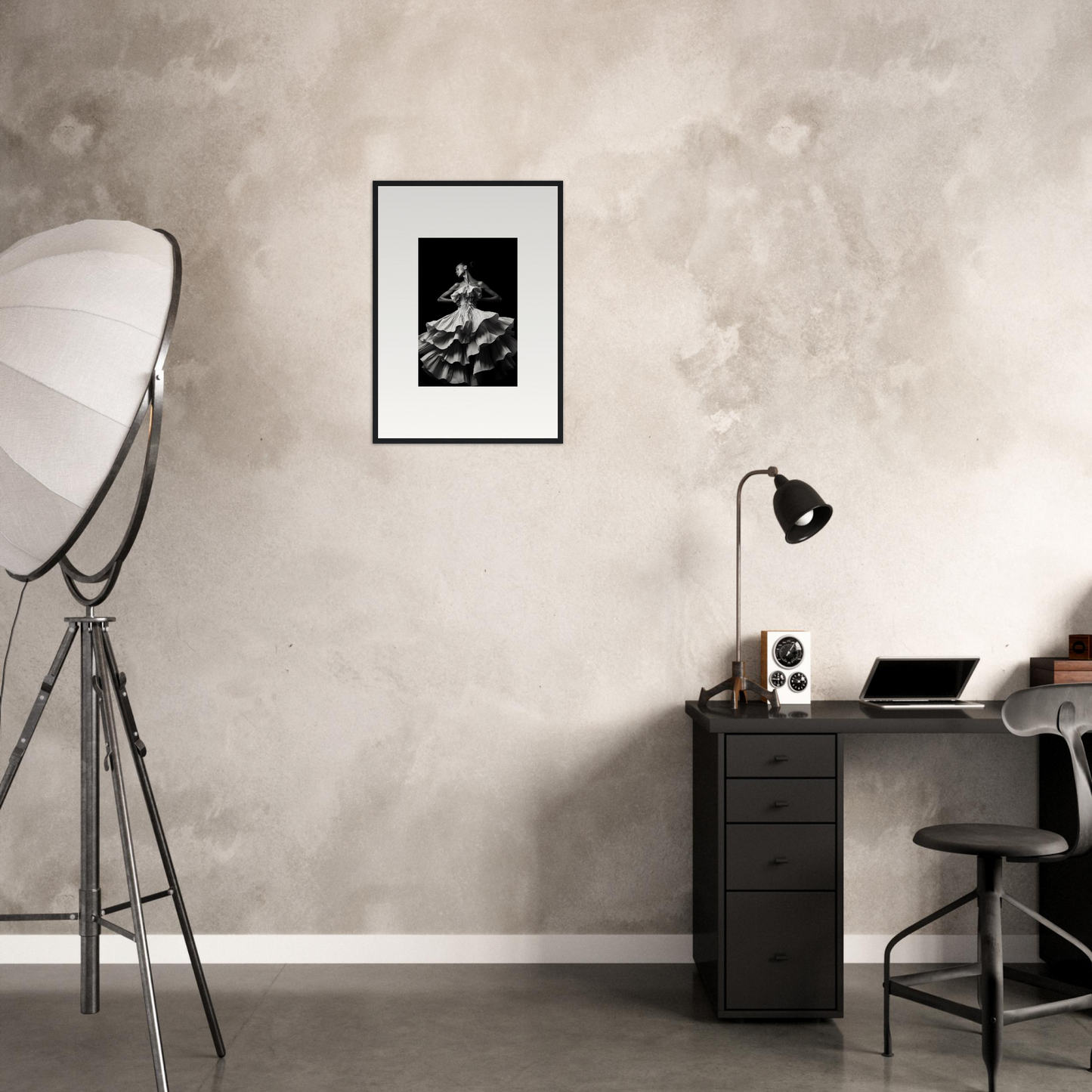 Minimalist home office workspace with a desk, chair, and framed artwork on the wall.