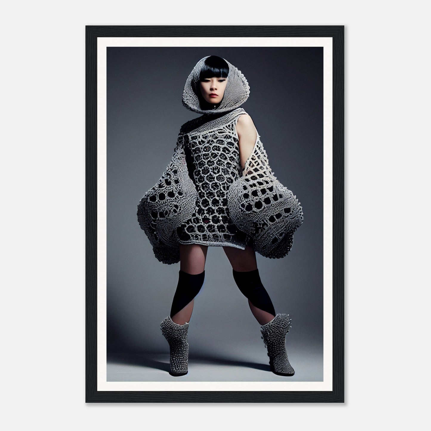 Avant-garde knitted dress with exaggerated geometric shapes and a hooded neckline.