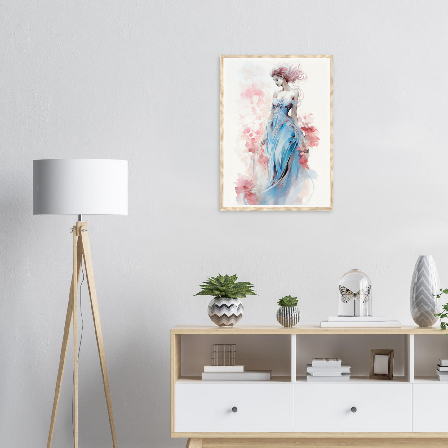Framed watercolor painting of an elegant woman in a blue dress surrounded by soft pink floral elements.