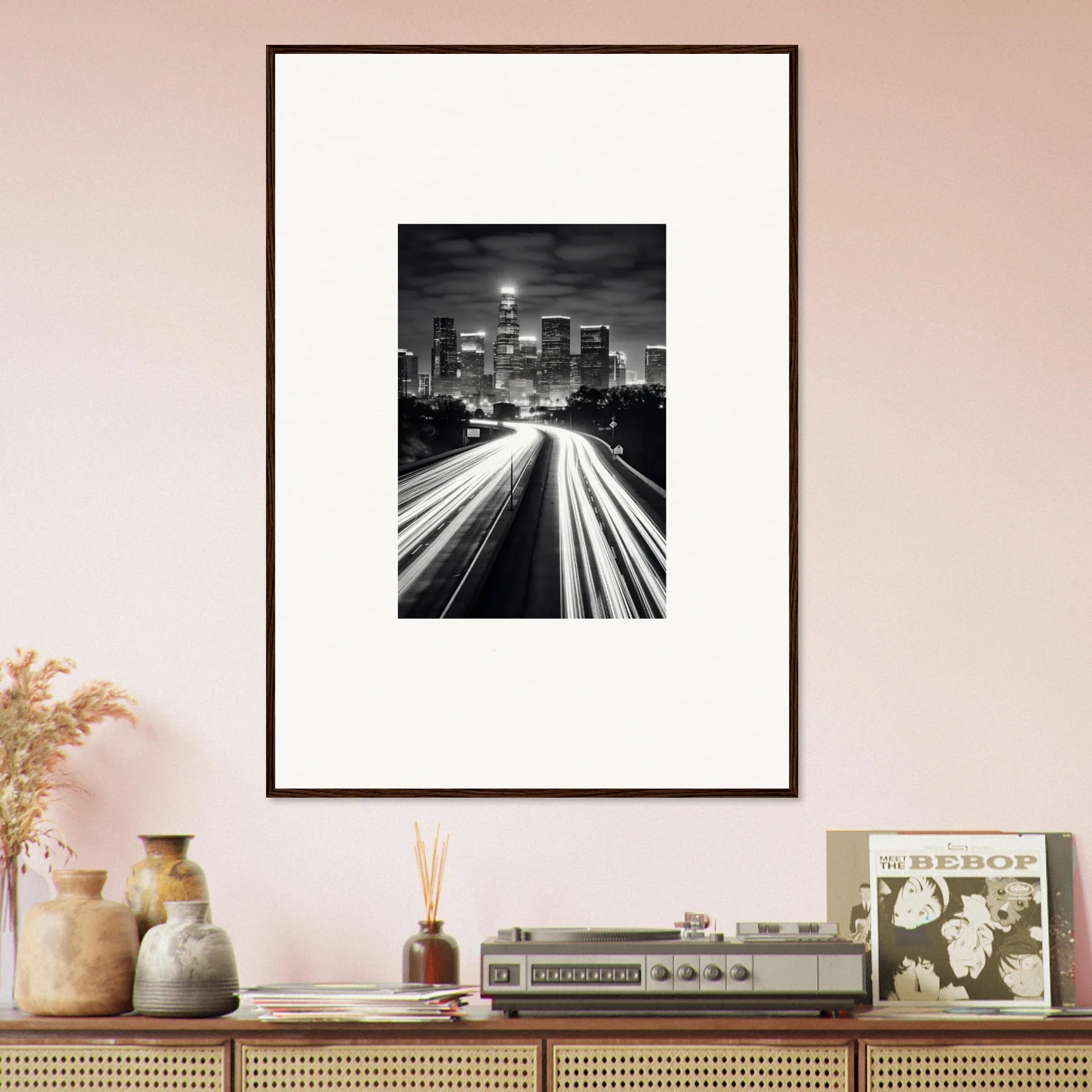 Framed wall art featuring a black and white city skyline with light trails below