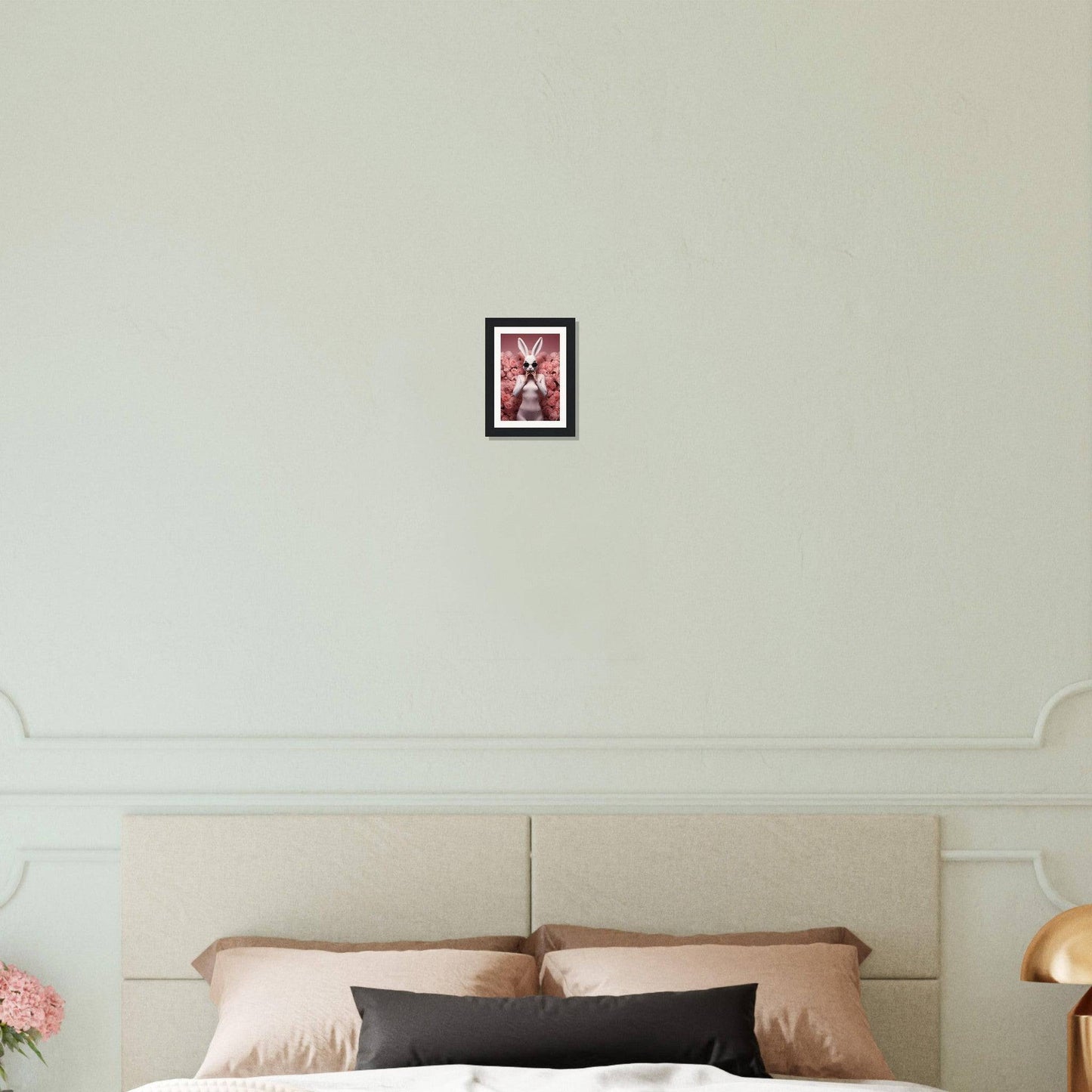 Framed artwork hanging on a white wall above a bed headboard.