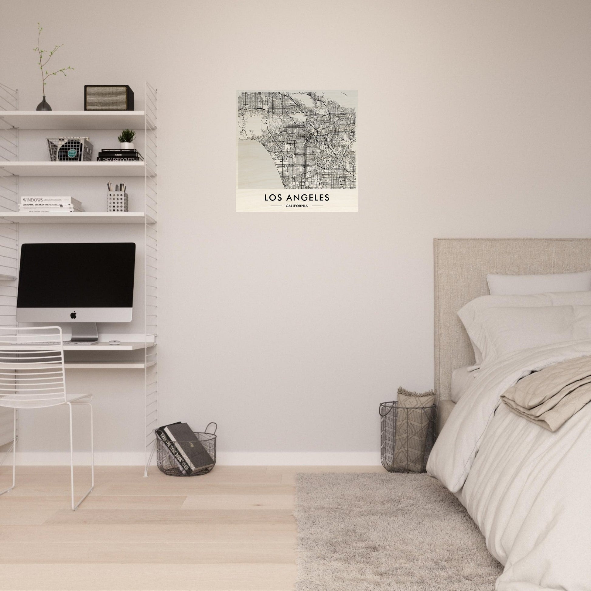 Minimalist bedroom with a workspace featuring white shelves and a map of Los Angeles on the wall.