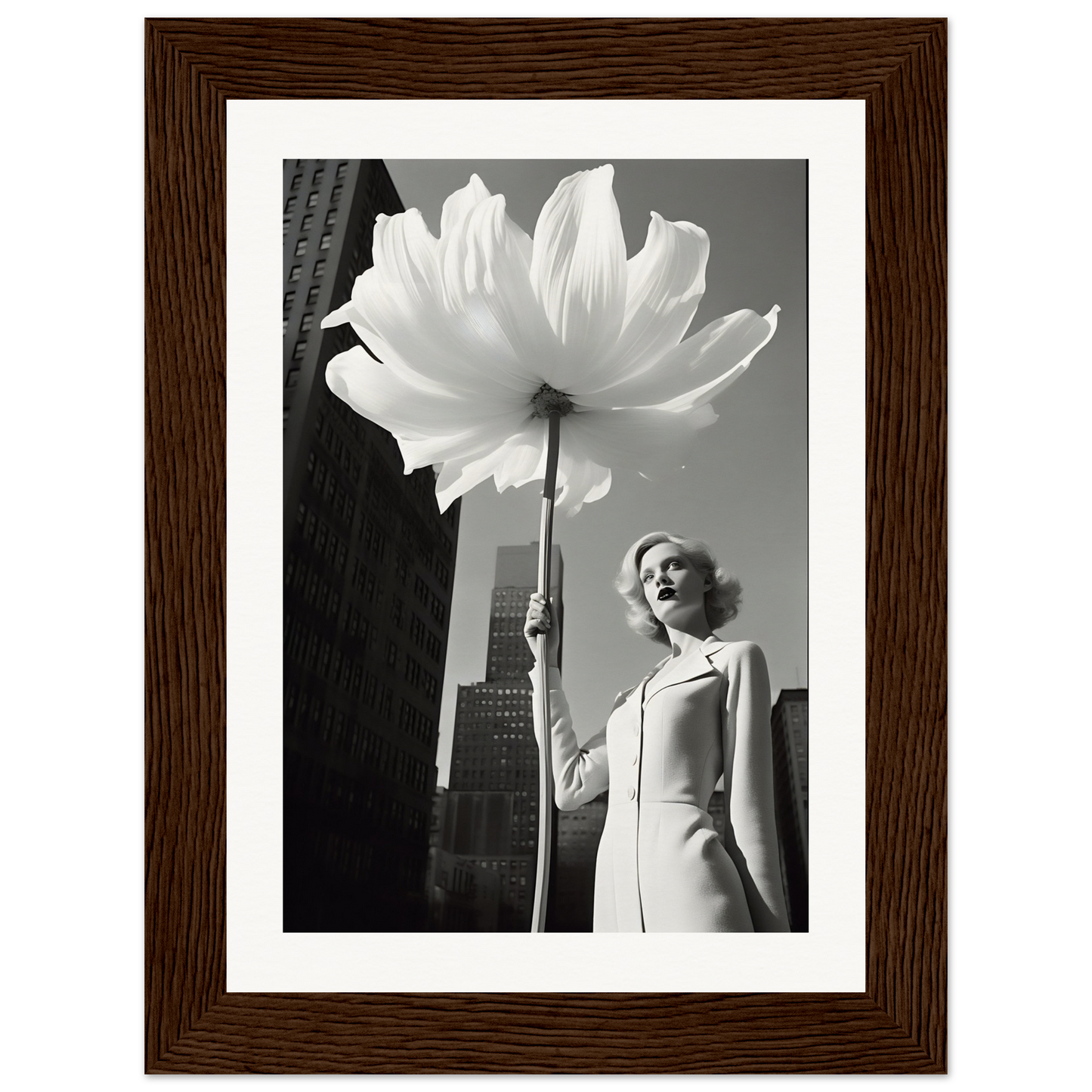 A woman holding a large white flower in front of a tall building