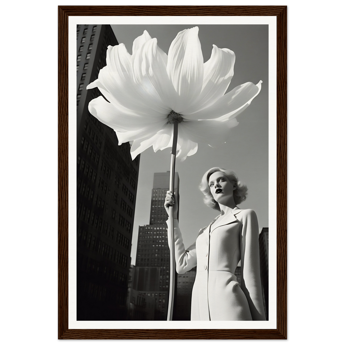A woman holding a large white flower in front of a tall building