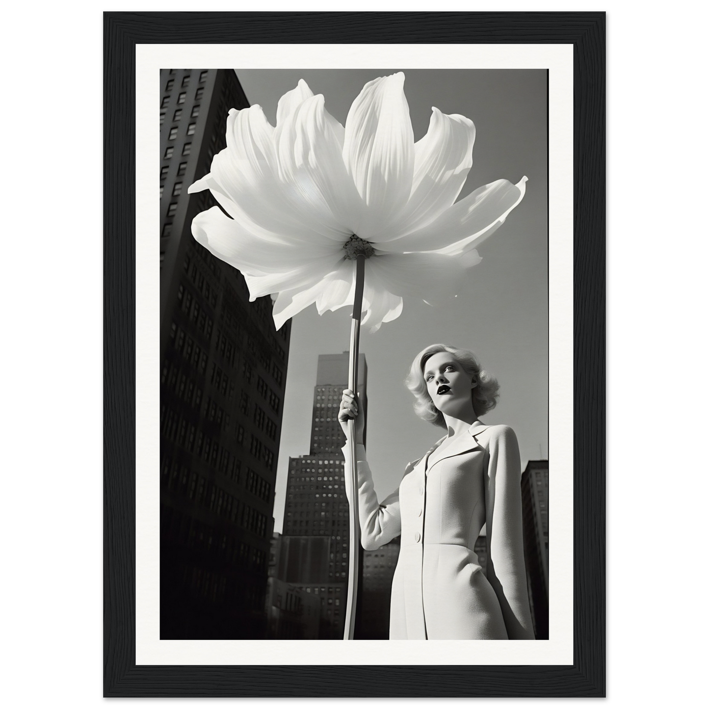 A woman holding a large white flower in front of a tall building