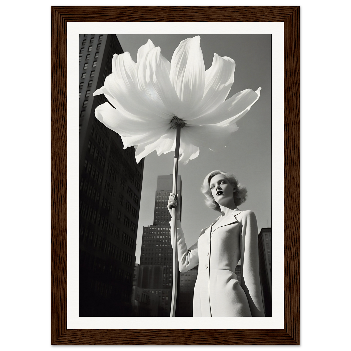 A woman holding a large white flower in front of a tall building