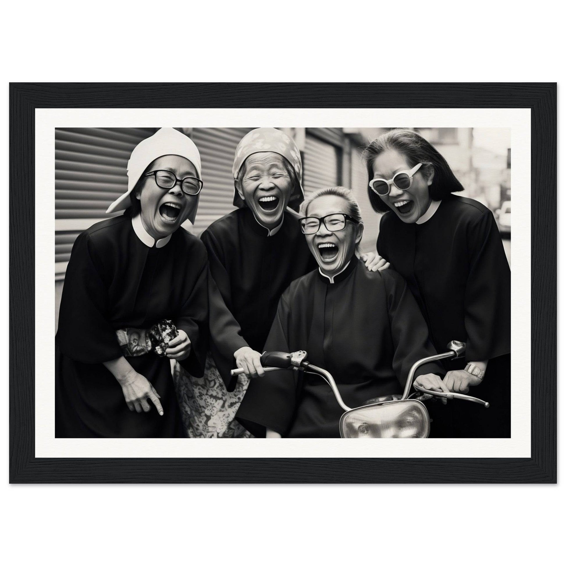 Black and white photograph of four laughing people wearing glasses and hats.