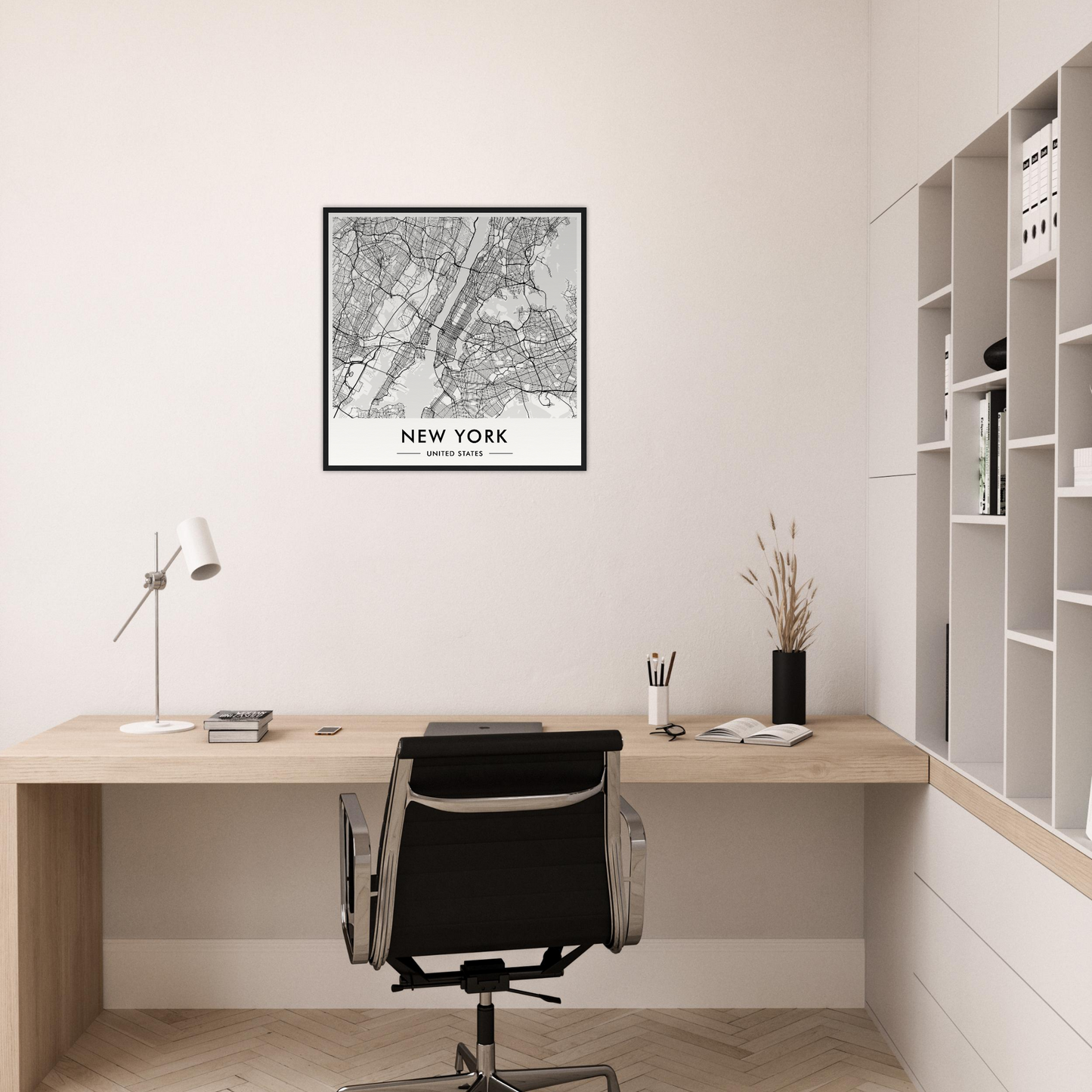 Minimalist home office workspace with a wooden desk, black office chair, and framed New York City map on the wall.