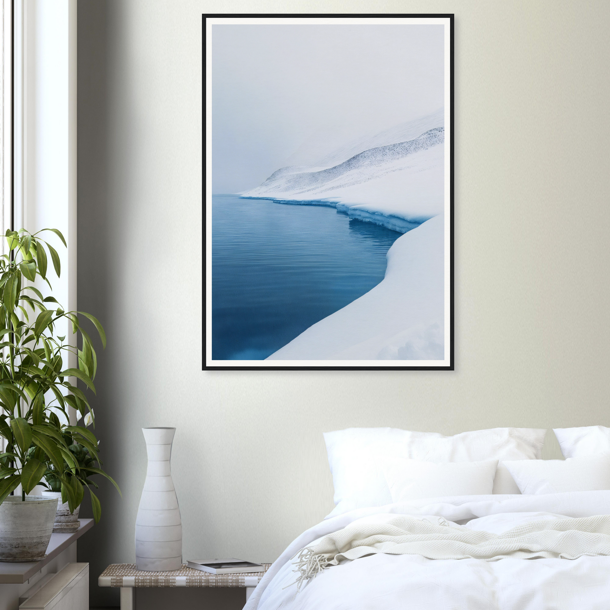 Framed wall art of snowy landscape above bed; plant and vase enhance the room decor.