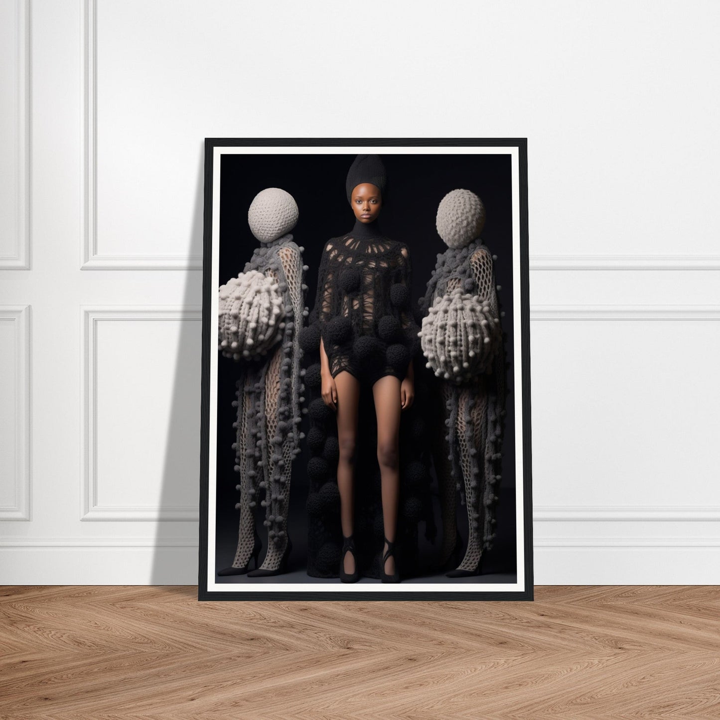 Framed photograph featuring a central figure flanked by two abstract sculptural forms.