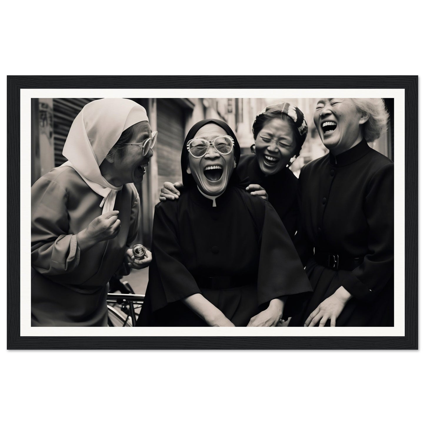 Black and white photograph of four women laughing joyously together.