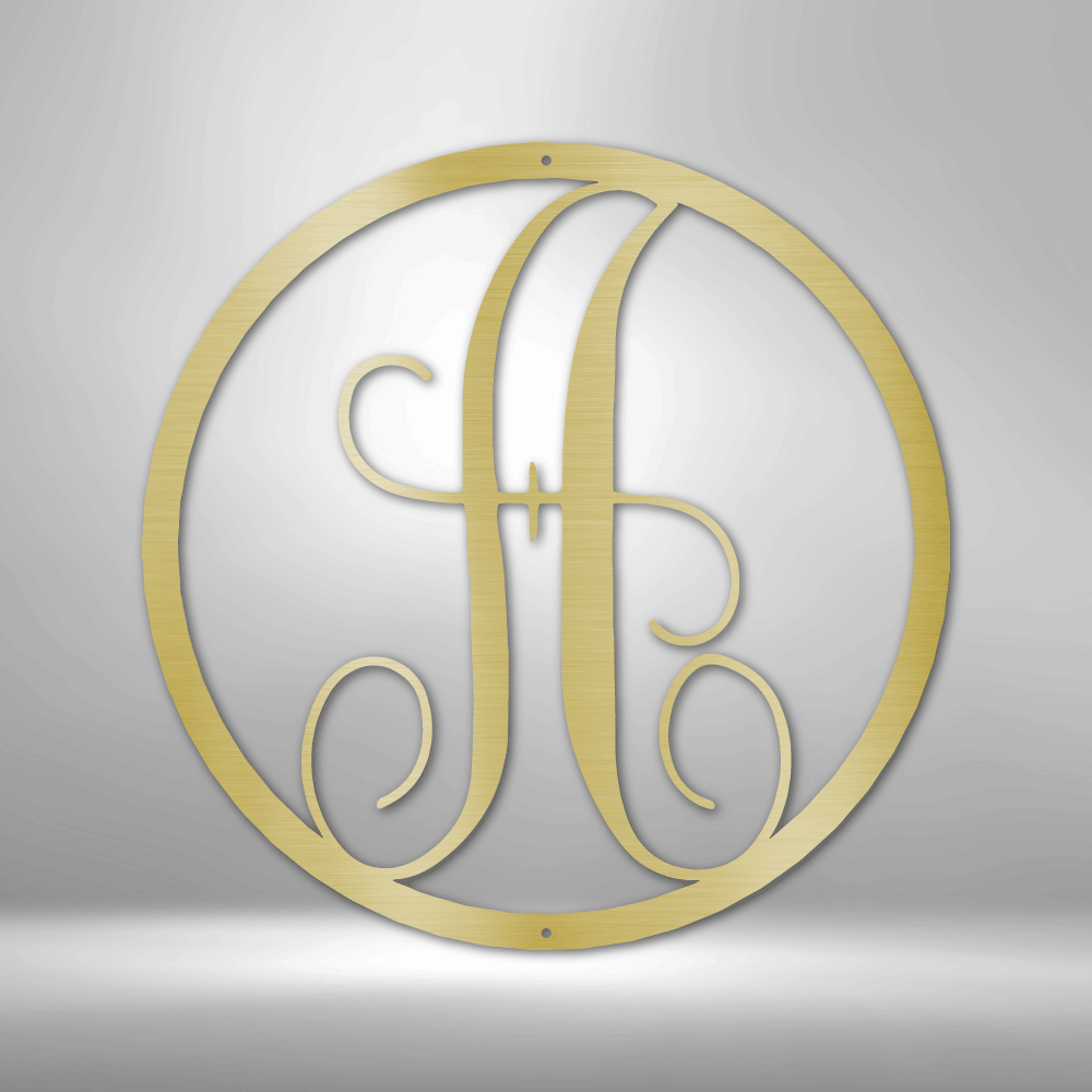 Circular gold monogram featuring an ornate letter ’A’.