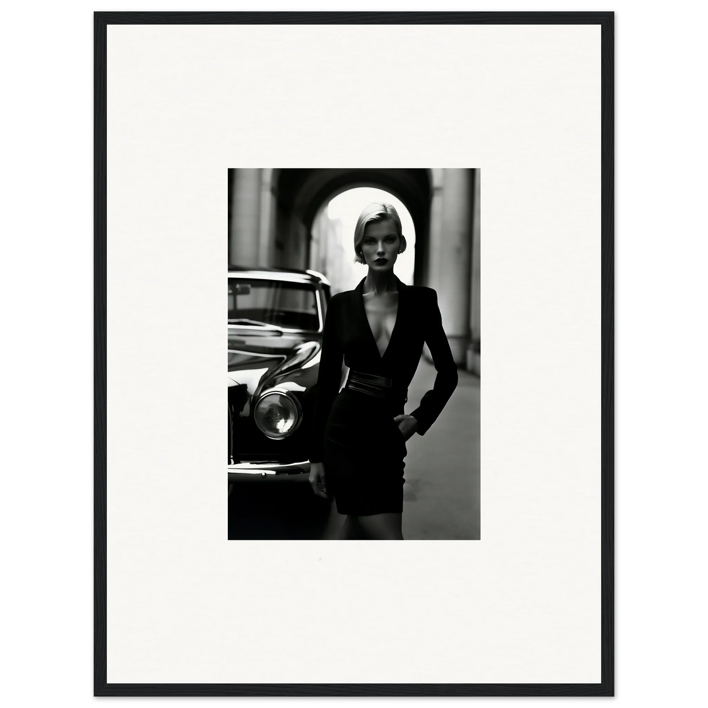 Black and white fashion photo of a figure in an elegant blazer dress next to a classic car for Interstellar Noir Illuminations