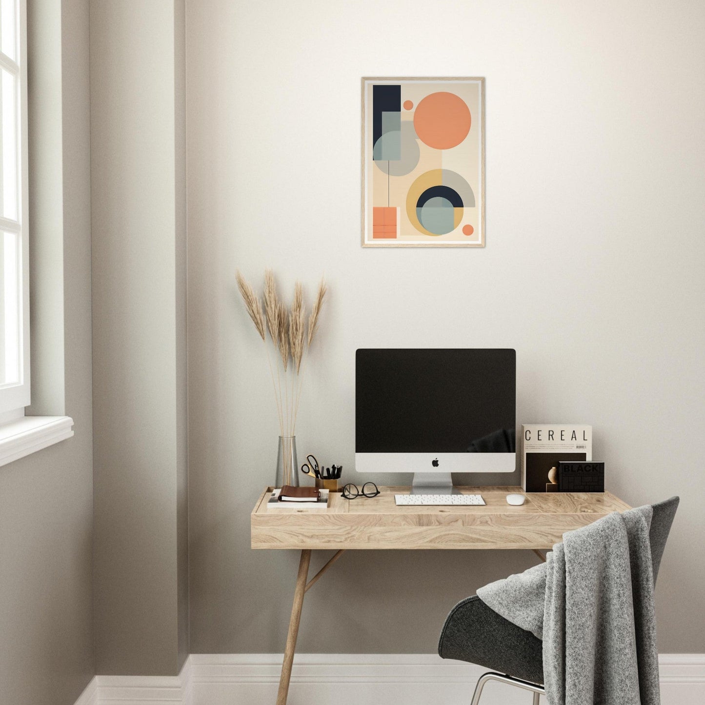 Minimalist wooden desk with a computer monitor and decorative artwork above.