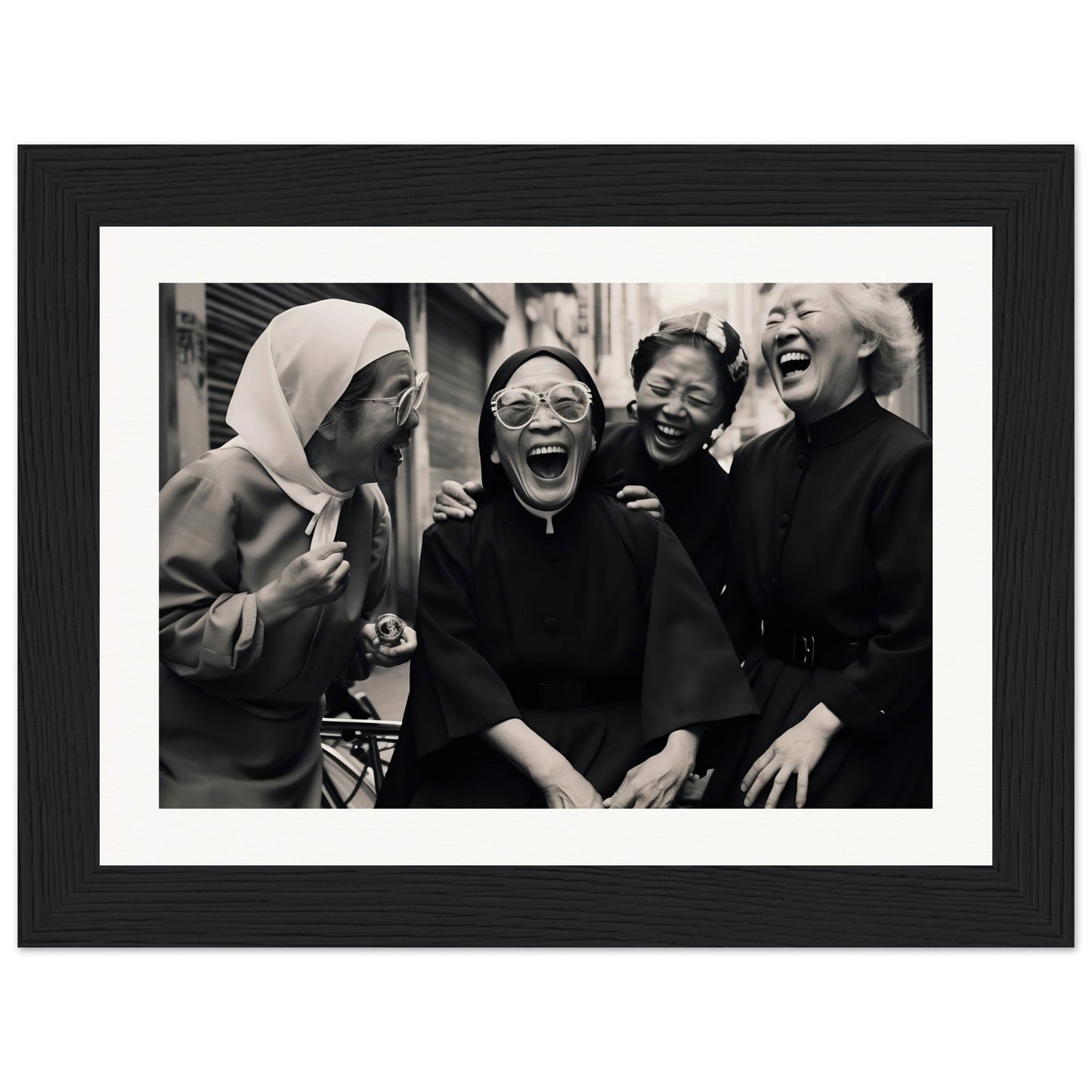 Black and white photograph of four women laughing together.