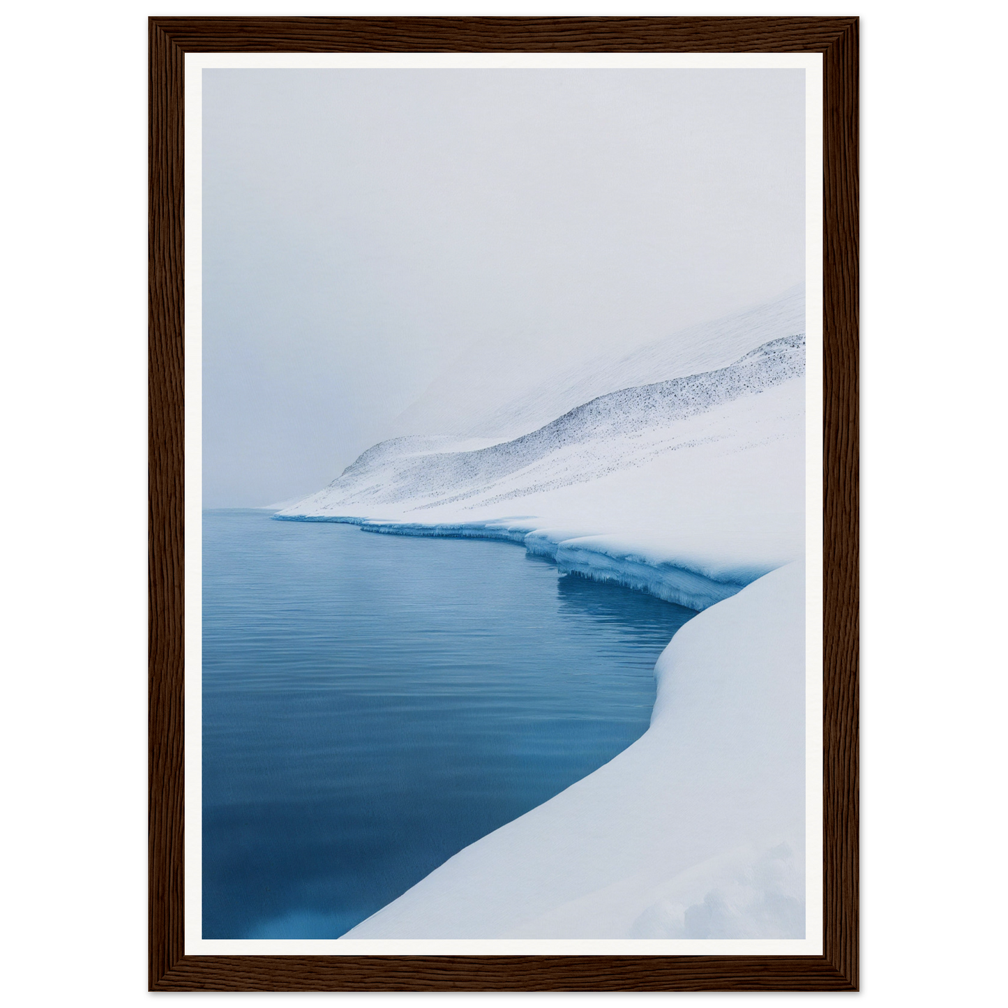 Framed wall art of a snow-covered landscape with a calm, blue lake under an overcast sky.