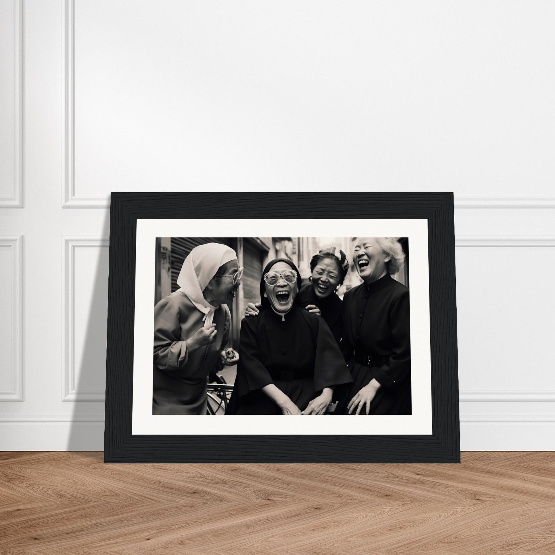 Framed black and white photograph of four people laughing together.