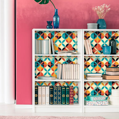 Colorful bookshelf with geometric patterned backing and various decorative objects.