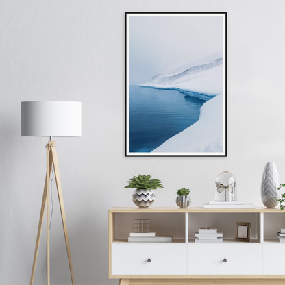 Living room with framed wall art of a snowy lake, a lamp, cabinet, and decor items.