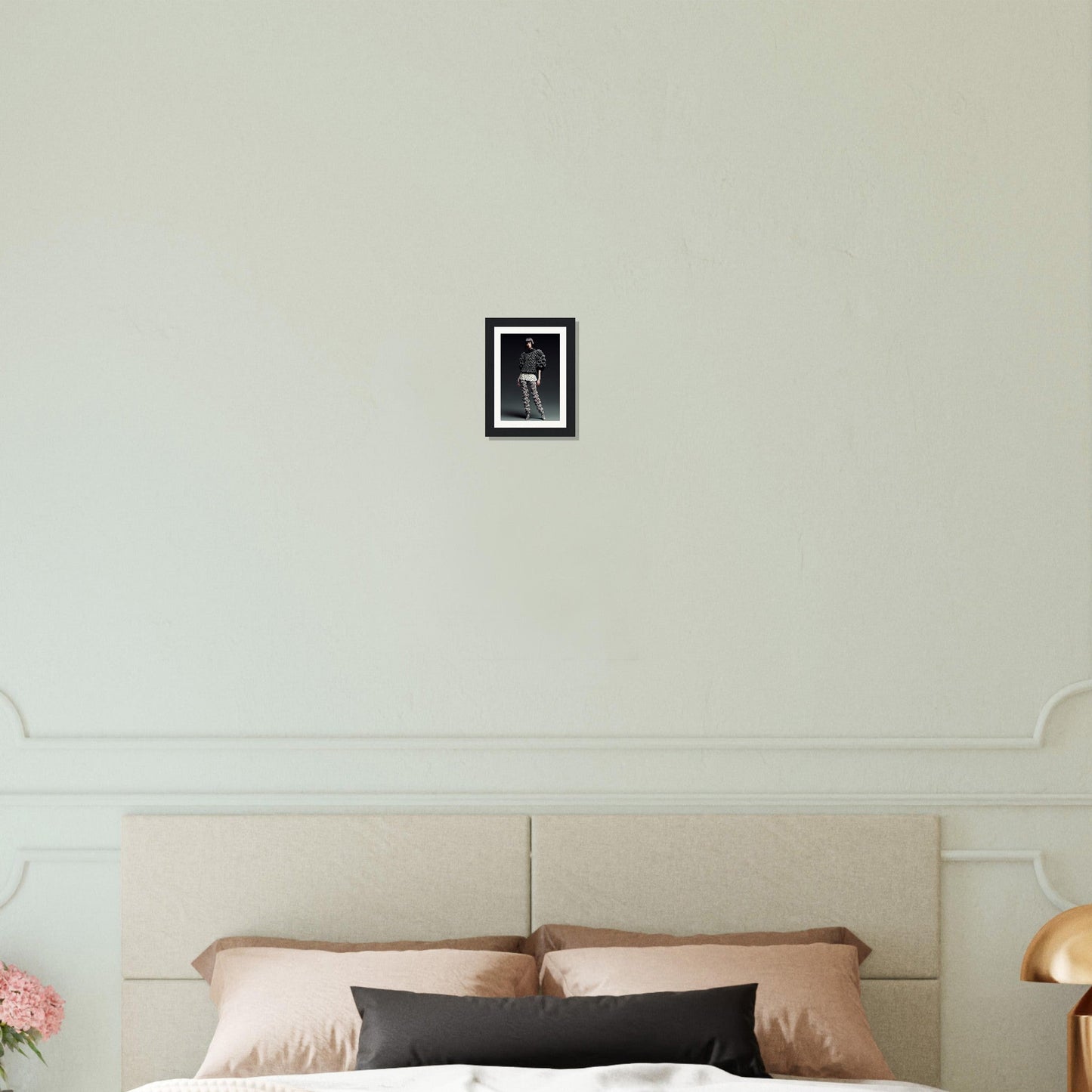 A bed with a white headboard and a black and white picture frame